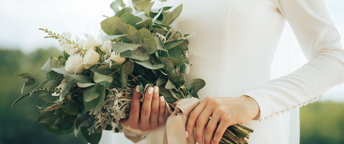 Bride holding bouquet of flowers close to her FULL web