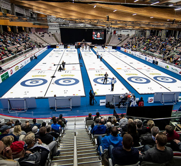 Curling rinks set up in WinSport Event Centre with crowd watching