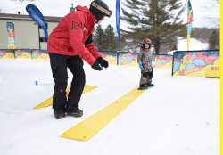 Instructor pulls young snowboarder using Burton reel