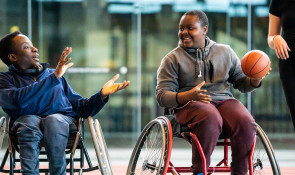 Two members of the WinSport Adaptive multisport program passing a ball to each other