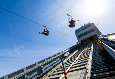 Two people zipping down the Monster Zipline at WinSport