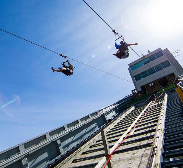 Two people zipping down the Monster Zipline at WinSport
