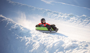 Child having fun while gliding down the Servus Tube Park at WinSport