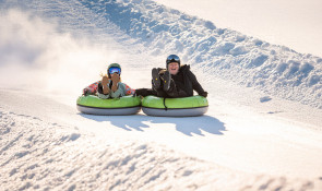 Mother and daughter sharing a ride down the Servus Tube Park at WinSport