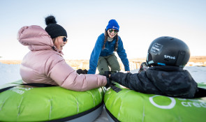 Parent and child getting ready to slide down the Servus Tube Park at WinSport
