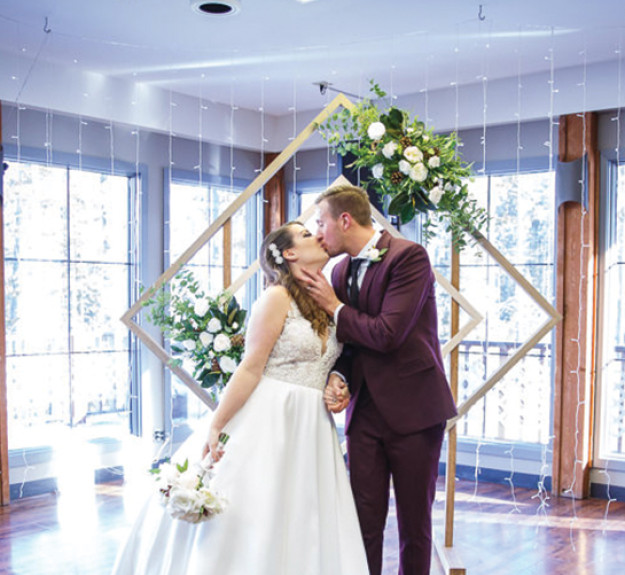 Bride and groom kissing during their wedding at Bill Warrent Training Centre in Canmore