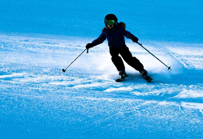 Lone skiier carving down the ski hill at WinSport 