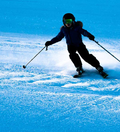 Lone skiier carving down the ski hill at WinSport 