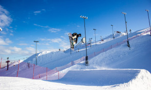 Snowboarder going off a jump at the WinSport terrain park