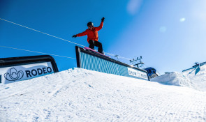 Snowboarder hitting a rail at the snow rodeo at WinSport