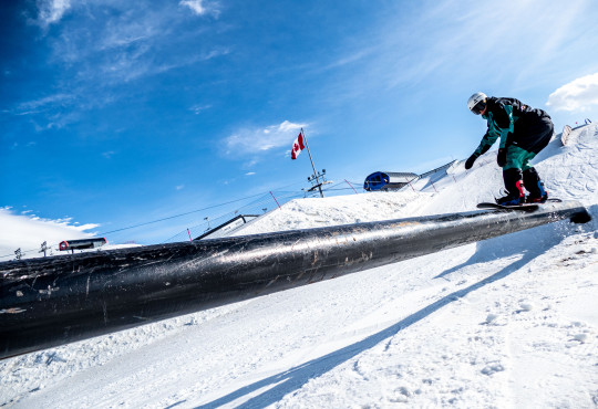 WinSport freestyle snowboarder on rail