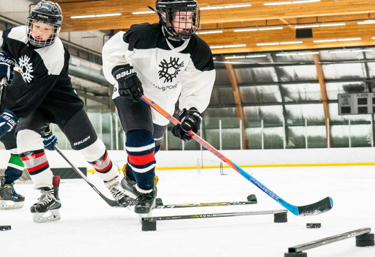 Group of boys skating through a hockey drill on ice