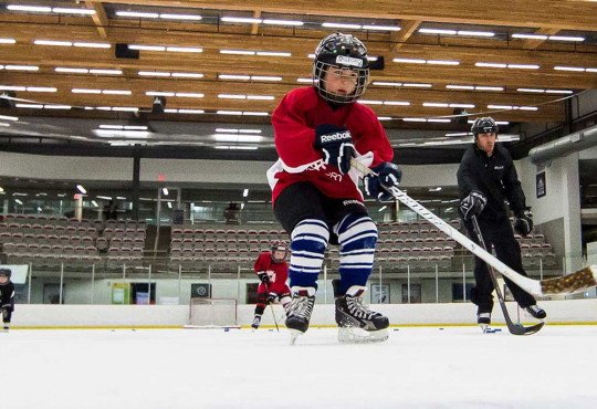 Group of kids power skating on ice