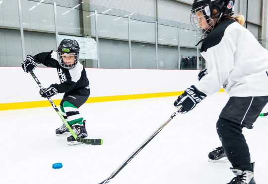 Young boy passing a puck into an open net