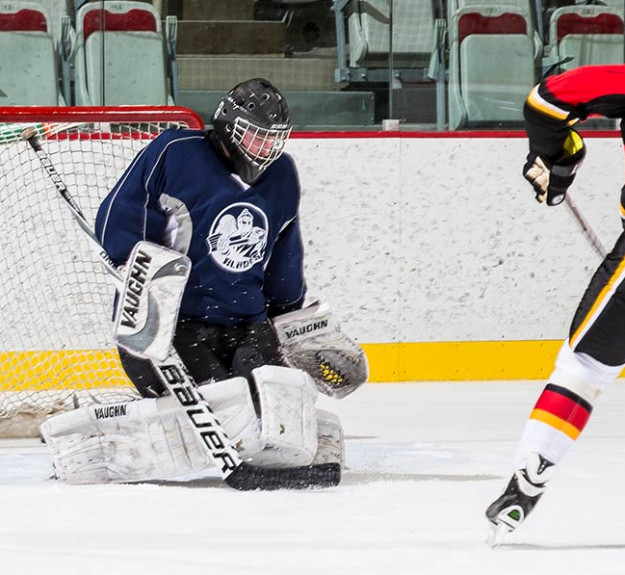 Hockey player on a breakaway against a goalie in WinSport Event Centre