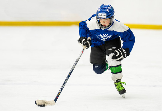 u13 player skating with the puck in open ice at WinSport