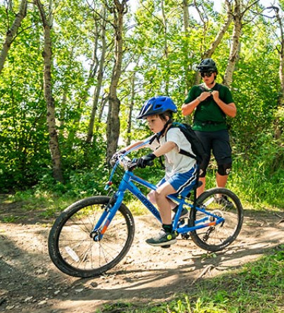 Kid learning how to bike during a private lesson on a closed trail at winsport