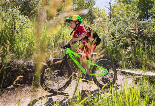 Child participating in Mini Enduro camp at WinSport on his mountain bike
