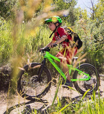Child participating in Mini Enduro camp at WinSport on his mountain bike