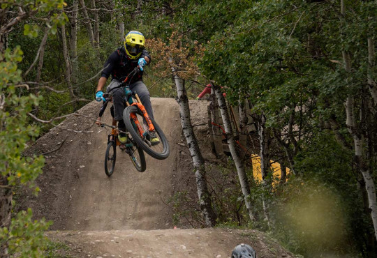 Mountain Biker getting air off a dirt jump followed by another rider