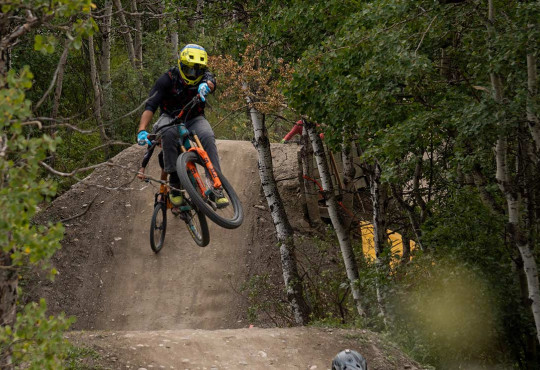 Mountain Biker getting air off a dirt jump followed by another rider