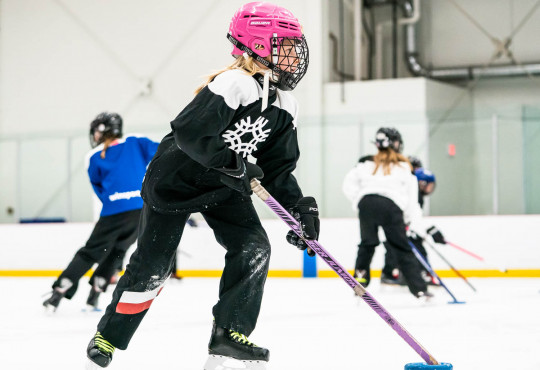 Winsport RingetteU10 girlinpinkhelmetskateswithring