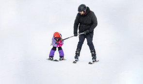 Parent and tot learning how to ski together