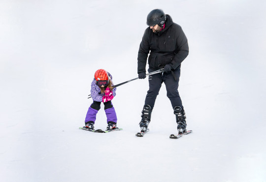 Parent and tot learning how to ski together