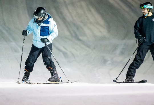 Two adults skiing on snow at WinSport