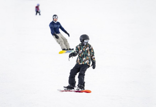 Teen snowboard learning how to snowboard down the hill at WinSport