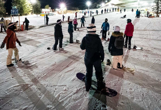 Group of night time skiiers taking a lessons on the bunny hill at winsport copy