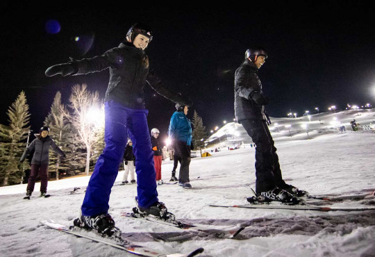 Group of women learning to ski at night