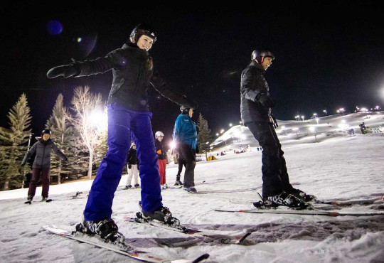 Group of women learning to ski at night