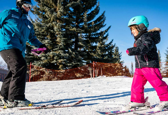 Instructor and young girl smiling during a ski lessons at winsport copy