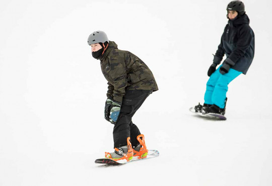 Two teenage boys snowboard on a whiteout day at winsport copy