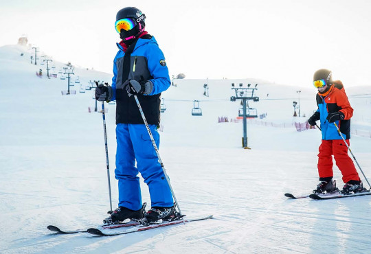 Two teenagers skiing on the hill at WinSport
