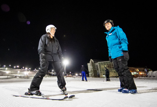 Winsport ski lesson woman with instructor night skiing