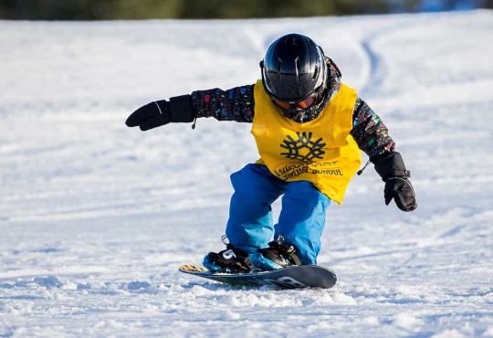 Young child learning how to stop on their snowboard copy