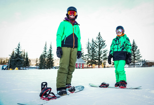 Winsport Snowboard teen boys wearing green snow suits posing with snowboards