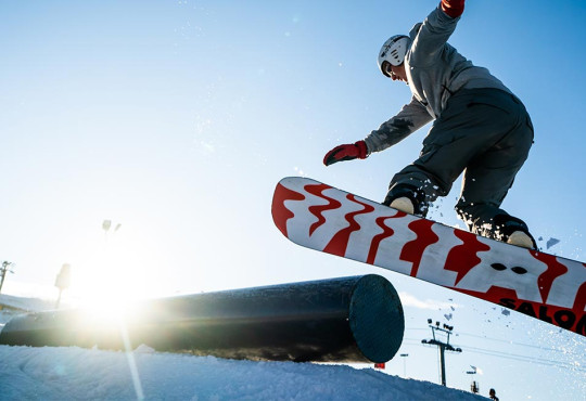 SBBasicsnowboarder doing a 180 while exiting a rail at winsport