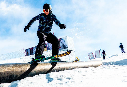 adult sliding down a rail at the terrain park at winsport