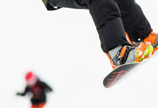 close up shot of a snowboarder gliding down the hill