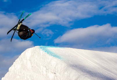 skiier doing a backflip off a slopestyle jump at winsport