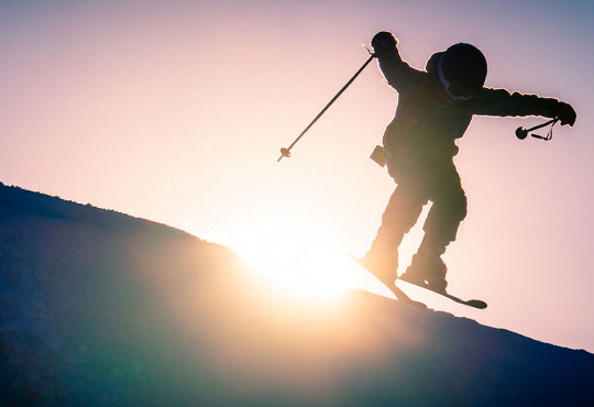 young skiier rolling over a slope at winsport