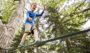 WinSport SummerCamps youngboywalksonslacklineinforest