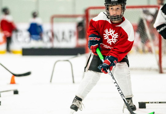 Group of children developing their hockey skills at a summer camp