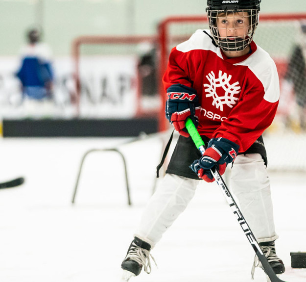 Group of children developing their hockey skills at a summer camp