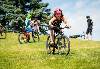 Winsport SummerCamps girlridingherbikethroughconesdownahill