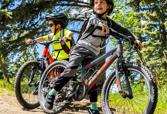 two friends learning how to bike during a lesson